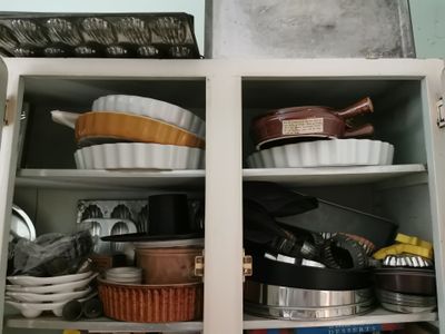 de nombreuses casseroles et poêles rangées ensemble dans un placard