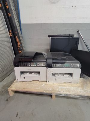 deux imprimantes posées sur une palette dans un entrepôt
