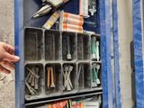a person holding a tool box with many different tools in it