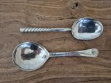 two spoons that are sitting on a wooden table