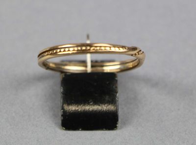 gros plan d'une bague en or sur une surface noire