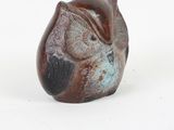 a small figurine of a cat on a white surface