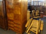 a large wooden armoire and a chair in a room