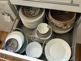 a picture of a kitchen with a drawer full of dishes