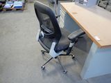 a desk with a chair and a computer monitor on it