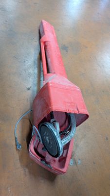 a red blow dryer sitting on the floor in a room