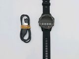 la montre se trouve à côté d'un chargeur et d'un câble