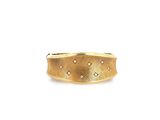 gros plan d'une bague en or sur fond blanc