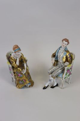 deux figurines représentant un homme et une femme assis sur une chaise