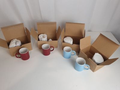 six tasses de café dans une boîte posée sur une table