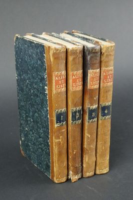 three old books are stacked on top of each other on a table