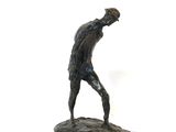 une statue représentant un homme tenant une batte de baseball au sommet d'un rocher