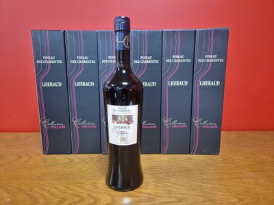 une bouteille de vin posée sur une table à côté d'une pile de livres