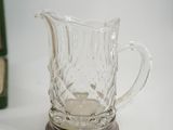 a glass pitcher sitting on top of a table next to a book