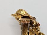 a gold brooch with a bird on top of it