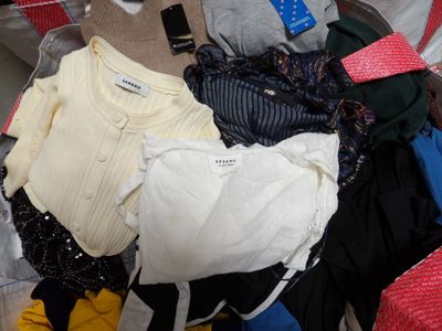 a pile of clothes that is sitting on top of a suitcase