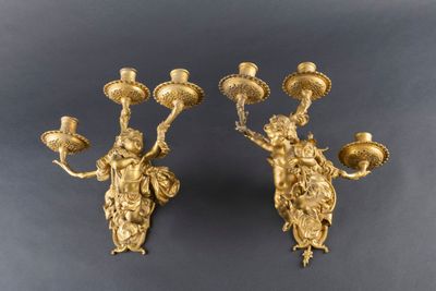 pair of antique brass candlesticks with cherenshes on them