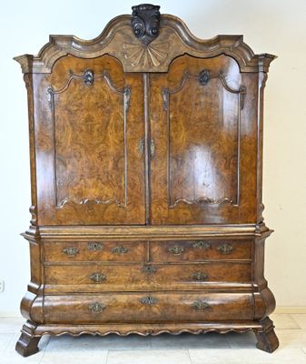 une vieille armoire en bois ornée de sculptures raffinées sur le dessus