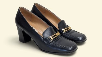 un gros plan sur une paire de chaussures noires posées sur une surface blanche