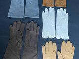 six pairs of leather gloves are lined up on a table