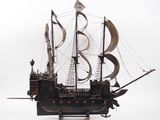 a model of a pirate ship on display on a white surface