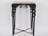 une table en fer noir avec un plateau en marbre, sur fond blanc