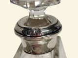 a clear glass bottle with a silver lid on a table