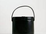 un sac seau noir muni d'une anse, sur fond blanc