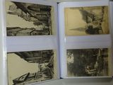 a hand holding an open book with pictures of buildings on it
