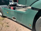 a green semi truck parked on the side of the road