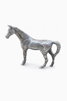 une statue représentant un cheval debout sur une surface blanche