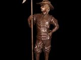 bronze statue of a man holding a flag and standing on a pedestal