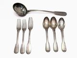 several spoons, forks and a spoon rest on a white surface