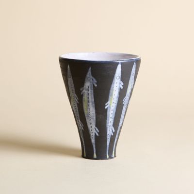 une tasse en noir et blanc sur laquelle sont peintes des plumes