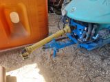 a blue tractor with a yellow hose attached to it