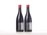 two bottles of red wine sitting next to each other on a table