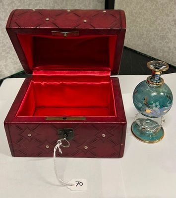 une petite boîte rouge avec un flacon de parfum à côté