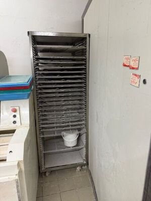une photo d'une cuisine professionnelle avec une étagère remplie d'aliments