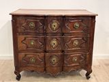 une commode ancienne avec des poignées en laiton et un plateau en bois