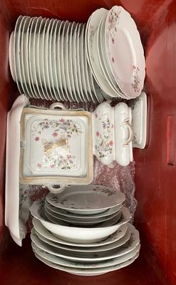 a lot of plates and bowls in a red box