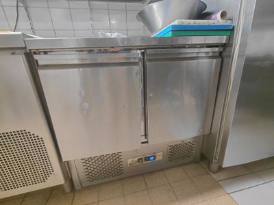 un réfrigérateur en acier inoxydable dans une cuisine, avec une casserole posée dessus
