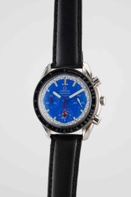 a close up of a watch with a blue face on a black strap