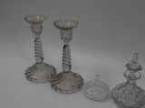 three glass candlesticks and a candle holder on a white surface