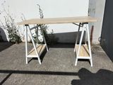 a wooden table with two shelves on it in front of a white wall