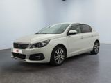 La voiture blanche est garée dans une pièce blanche au sol noir.