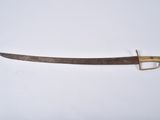 a close up of a knife on a white surface with a gold handle