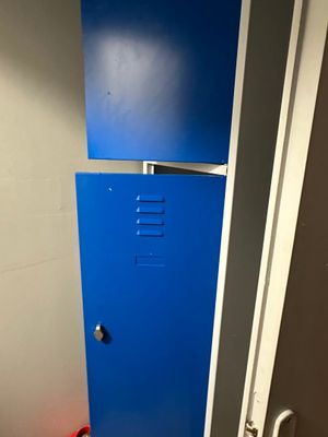 un casier bleu dans un coin des toilettes