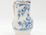 un vase bleu et blanc muni d'un couvercle, posé sur une surface blanche