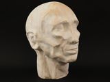 a close up of a sculpture of a man ' s head on a black background