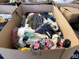 une boîte en carton remplie de vêtements posée par terre